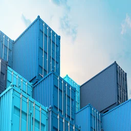 Blue containers stacked under blue sky