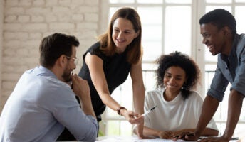 Smiling colleagues gathered around a desk