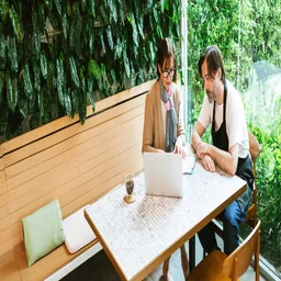 hospitality staff sitting at table working at computer