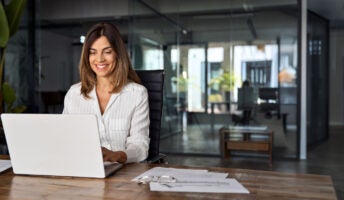 Smiling woman working on laptop