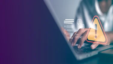 Person typing on laptop experiencing cybersecurity breach
