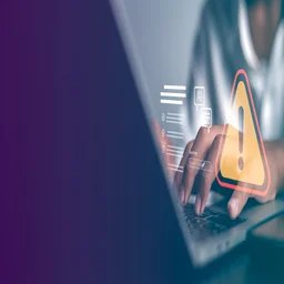 Person typing on laptop experiencing cybersecurity breach
