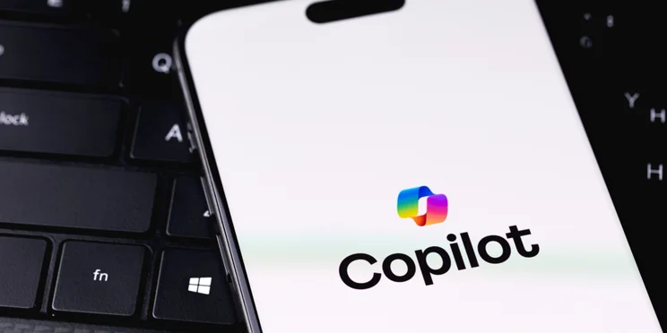 Copilot logo on phone screen on laptop keyboard