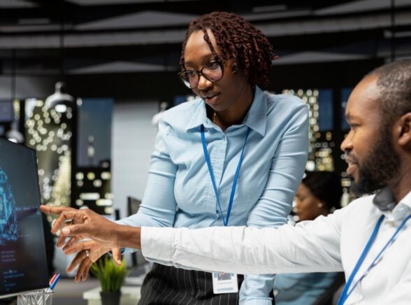 Employees looking at monitor on AI use