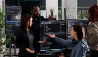 Employees surrounding computer in modern office