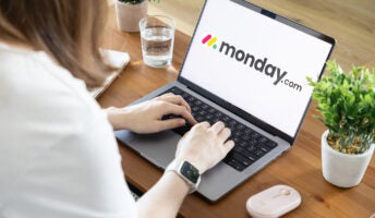 Person working on laptop with monday.com logo on screen