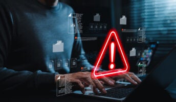 Person working on laptop with security alert detected