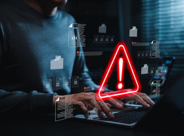 Person working on laptop with security alert detected