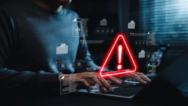 Person working on laptop with security alert detected