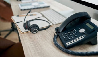 VoIP deskphone next to headset on office desk