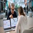 Business professionals collaborating over laptop screens