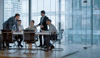 Workers in glass office collaborating