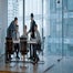 Workers in glass office collaborating