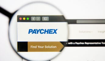 Paychex logo on computer screen, viewed through magnifying glass