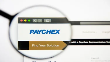 Paychex logo on computer screen, viewed through magnifying glass