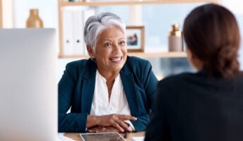 Manager over desk speaking to employee