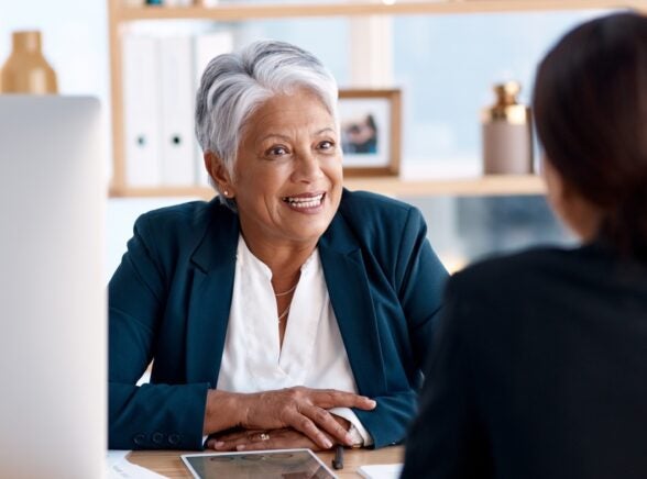 Manager over desk speaking to employee