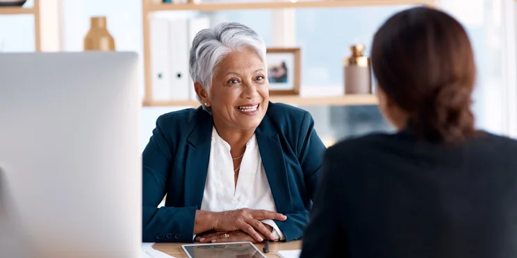 Manager over desk speaking to employee