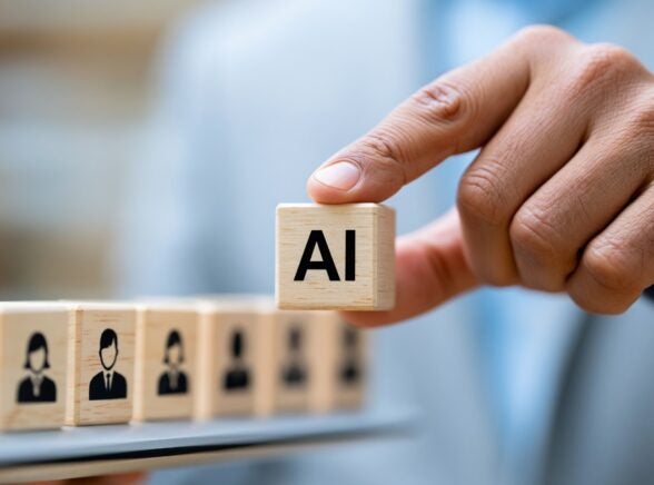 AI on wooden cubes with hand over candidates