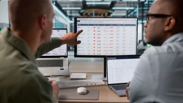Employees measuring performance on laptop