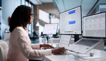 Woman working with AI on monitor and laptop