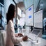 Woman working with AI on monitor and laptop