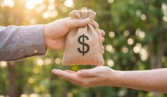 Person handing other person bag with dollar sign