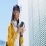 Young girl on phone smiling outside building