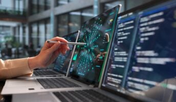 User on laptop with pen
