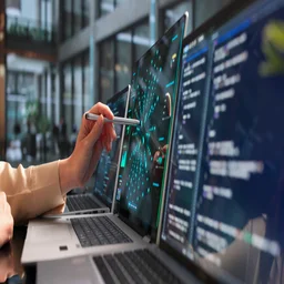 User on laptop with pen