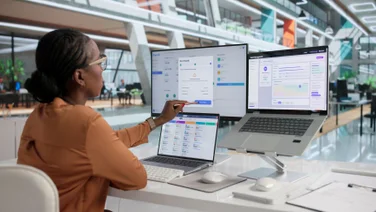 HR professional working with 3 monitors