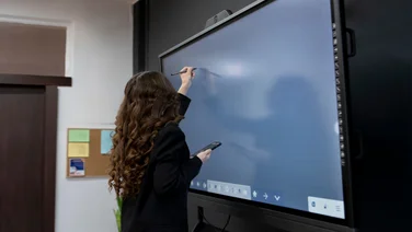 Woman writing on digital whiteboard