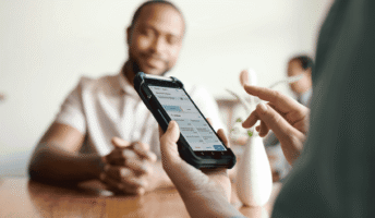 Hands holding a phone with unified commerce software