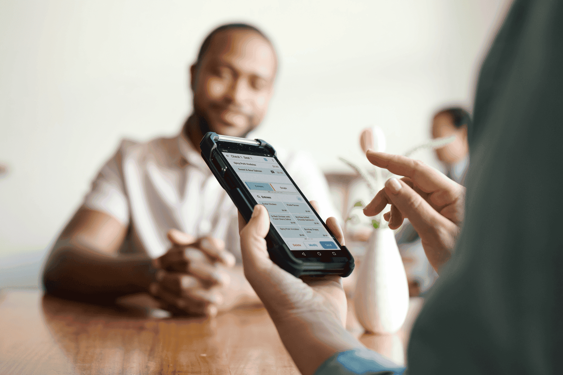 Hands holding a phone with unified commerce software