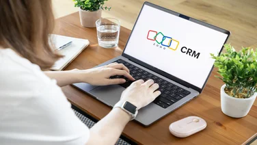 Office worker logging onto Zoho CRM on laptop