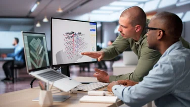 Office workers using project management software on laptop